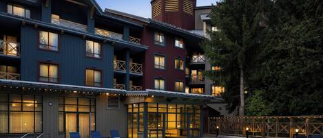 A hotel with a pool area, multiple balconies, and a distinctive tower.