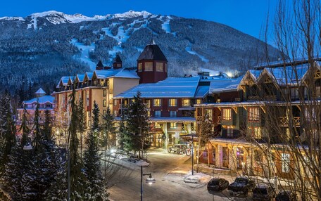 A snow-covered mountain town with traditional wooden buildings and a prominent church steeple.