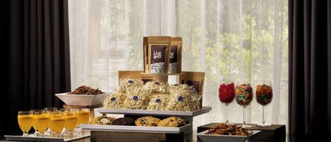 Ein Buffett mit Snacks, Getränken und einem verpackten Produkt mit der Aufschrift 'Live Nuts'.