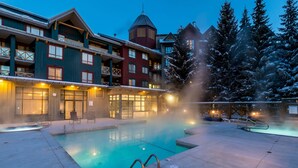 Un hotel con piscina, zona de estar al aire libre y un paisaje nevado.