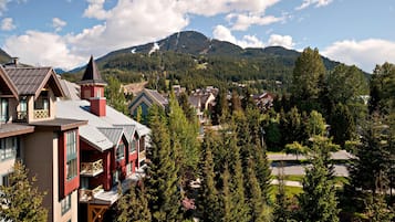 A mountain resort with a prominent building featuring a red facade and a tower.
