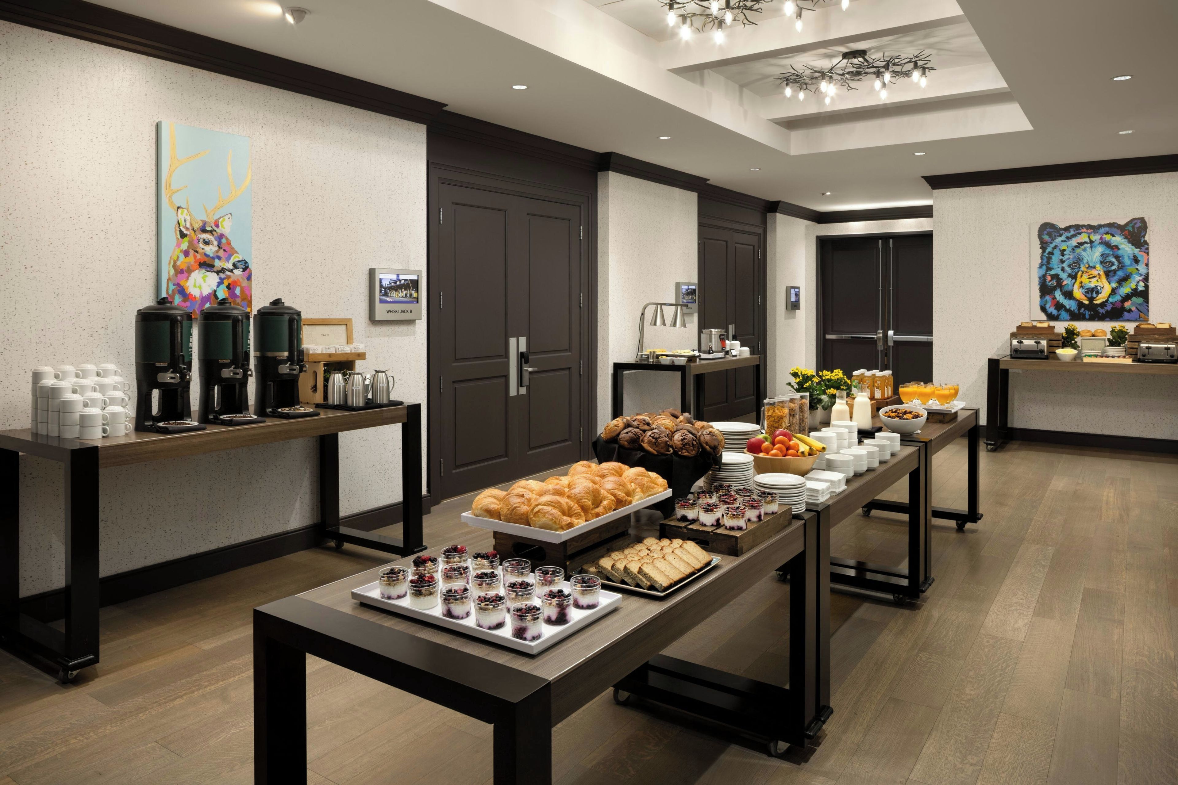 Disposição de buffet com diversos alimentos e máquinas de café.