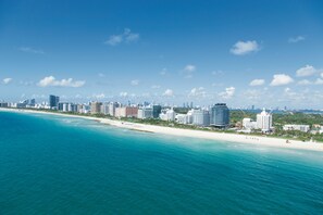 A coastal cityscape with a beach and high-rise buildings.