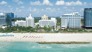 A beachfront hotel with multiple buildings, a sandy beach, and clear turquoise waters. - Hotel Riu Plaza Miami Beach (Miami Beach)