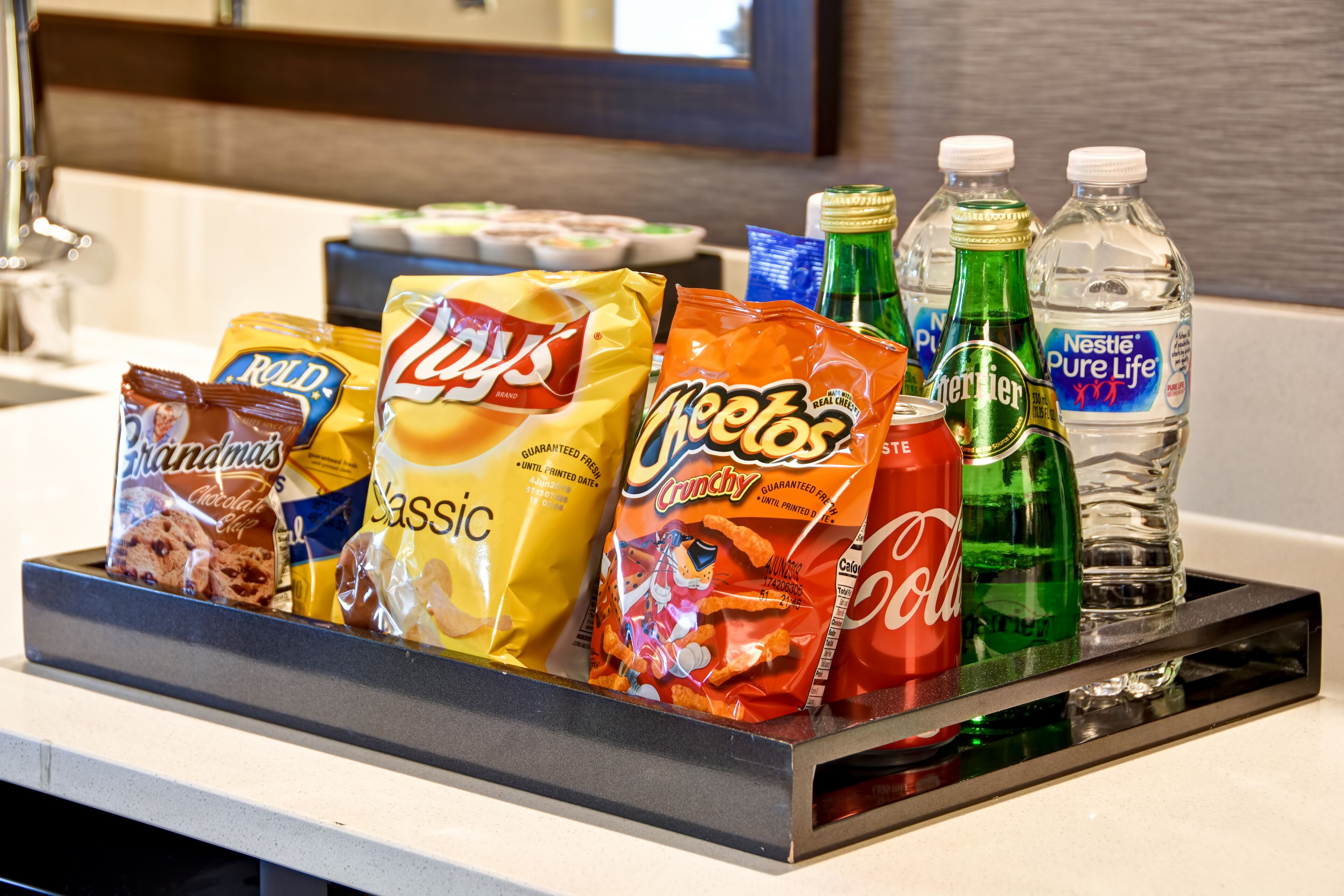 Un plateau avec des collations et des boissons sur le comptoir d’un hôtel.