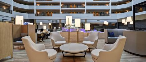 A spacious lobby with a central seating area, multiple floors, and a modern design.