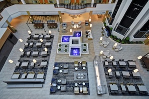 A spacious indoor area with multiple seating arrangements, including tables and chairs, and a central water feature.