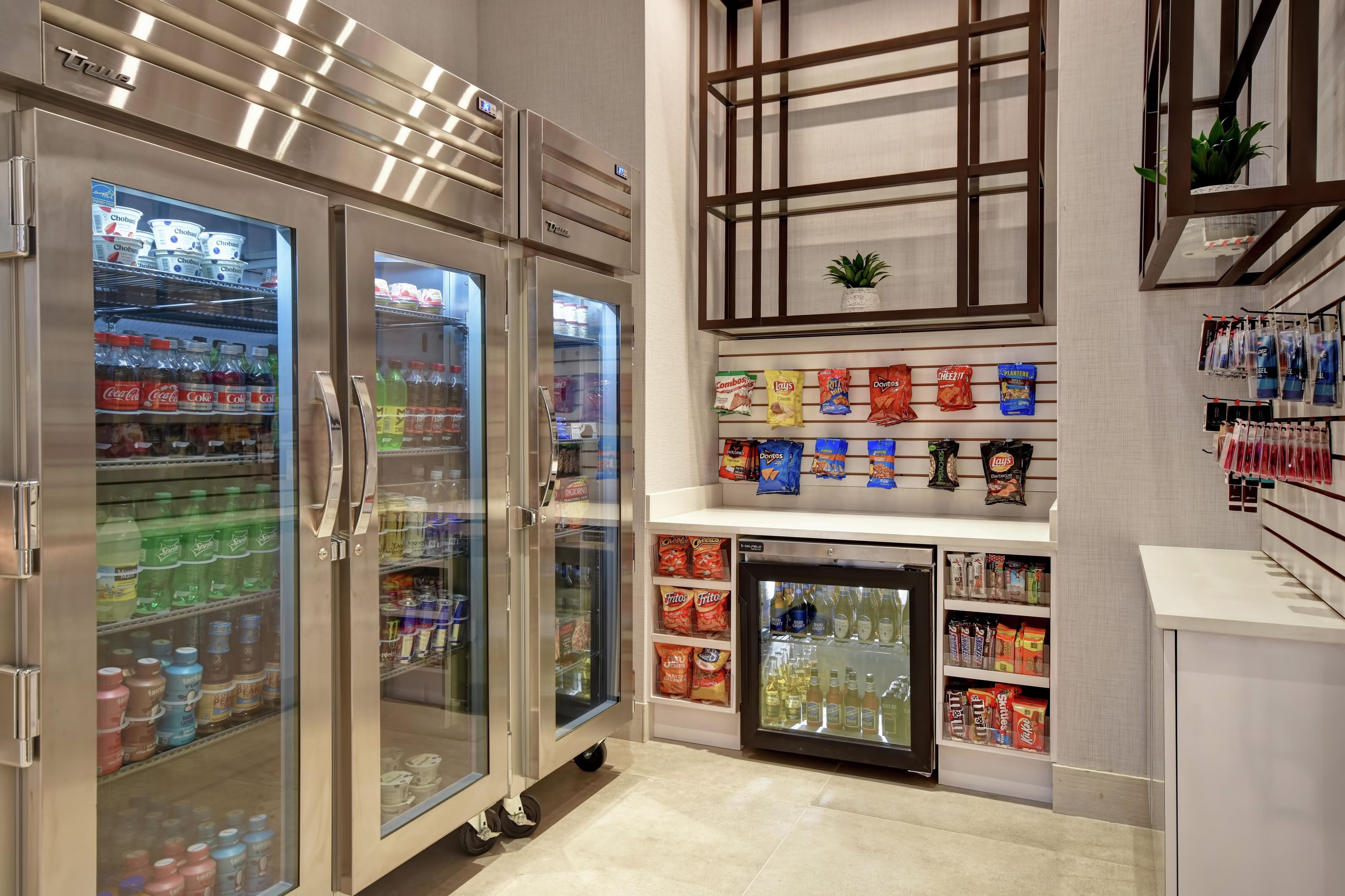 A self-service beverage area with refrigerated drink dispensers and snack shelves.