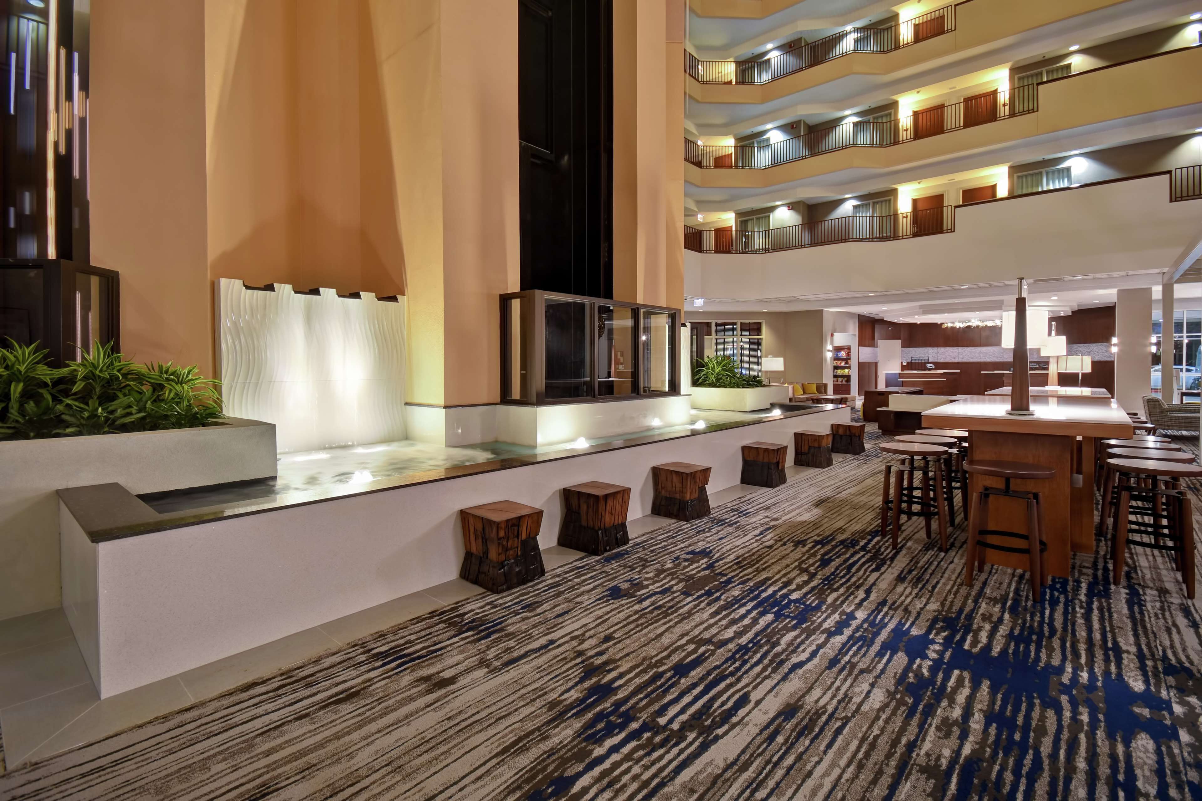 A spacious lobby with a reception desk, seating area, and a view of multiple floors.