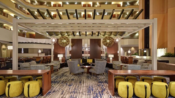 A spacious lobby with multiple seating areas, including sofas and chairs, and a central coffee table.