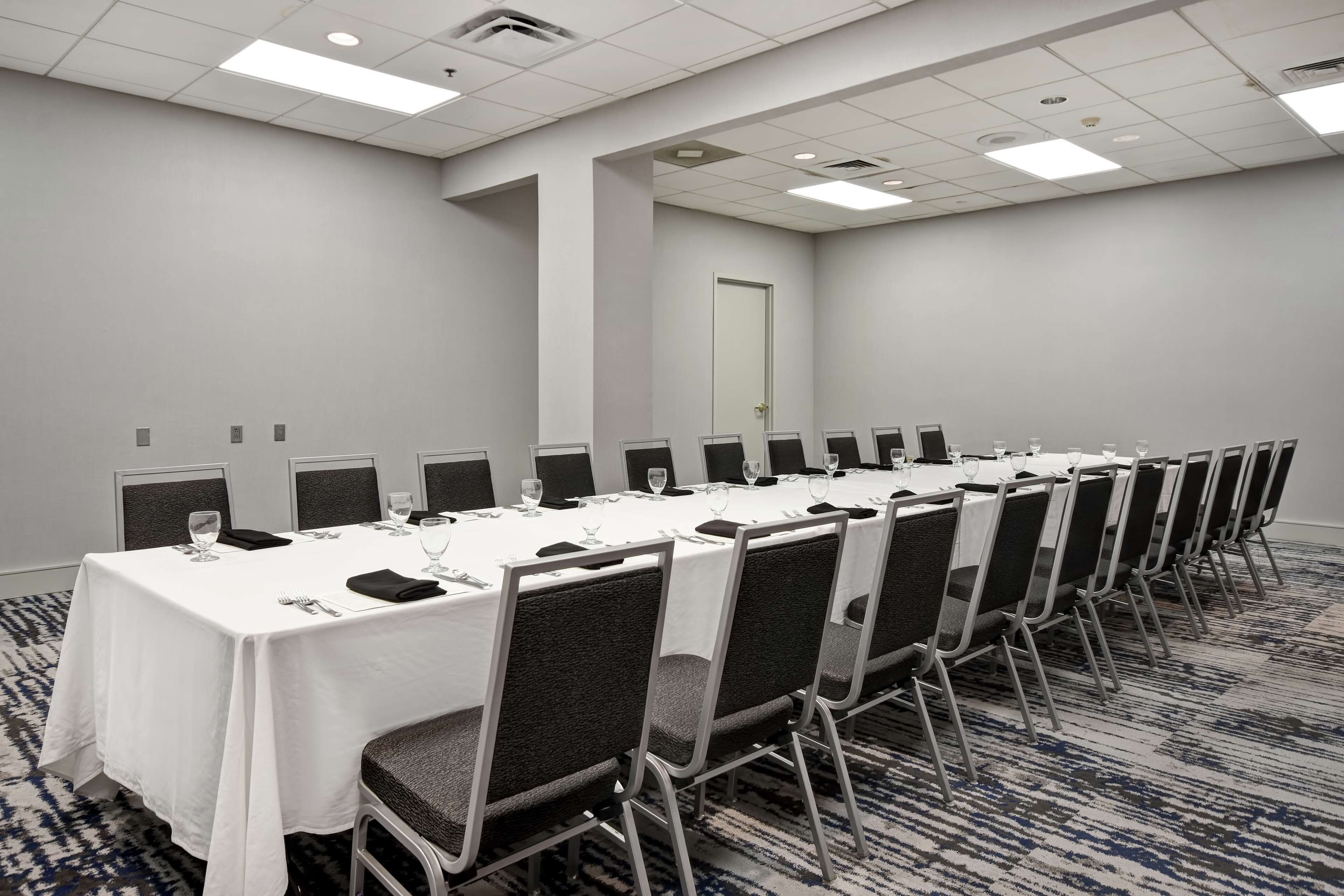 A conference room with a long table, chairs, and a door.