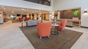 Un'ampia hall con soffitto alto, una reception e aree relax.