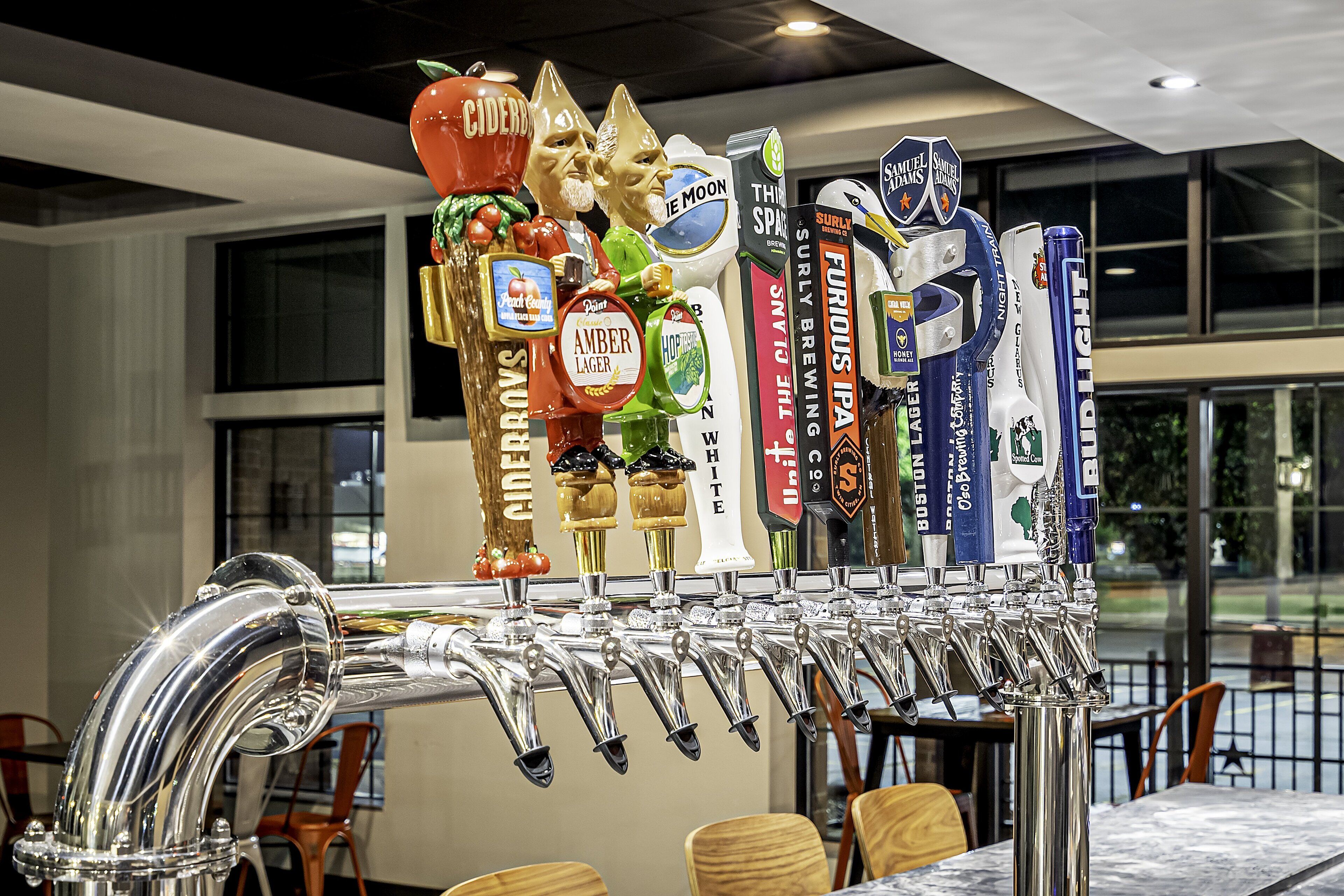 A tap system with various beer brands and a decorative figure.
