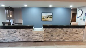A reception area with a stone wall, a clock, and a framed picture on the wall.