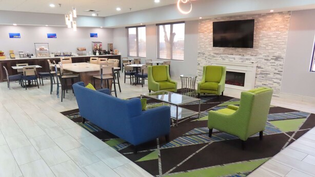 A modern lounge area with seating, a coffee station, and a fireplace.