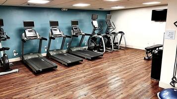A fitness center with treadmills, stationary bikes, and a rowing machine.
