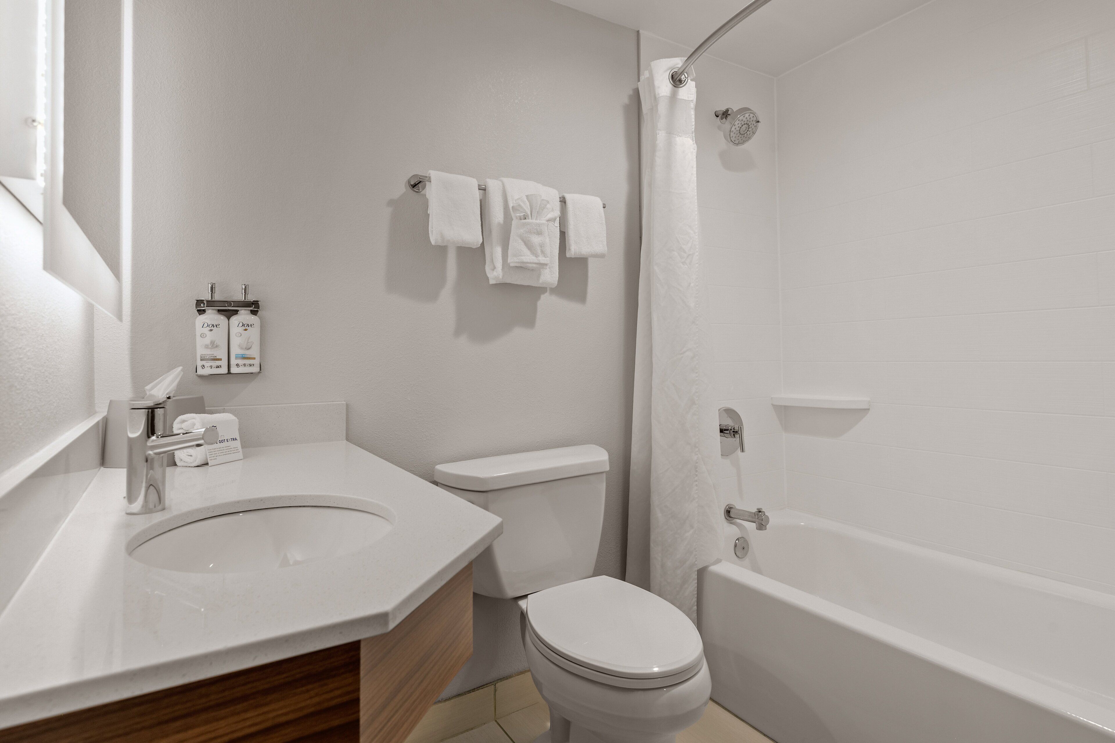 A modern bathroom with a sink, toilet, and bathtub.