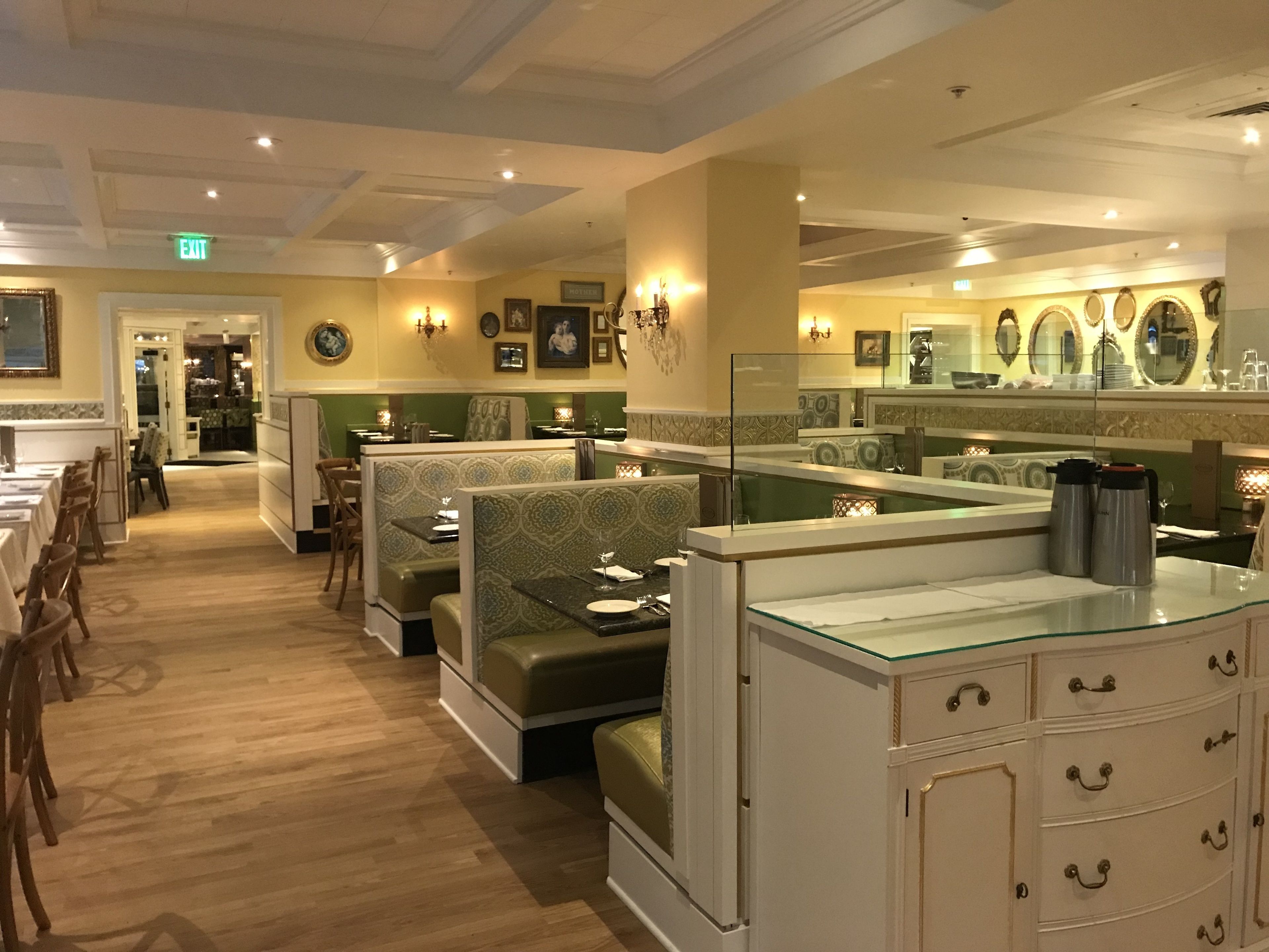 Un restaurant avec des banquettes, des tables et un coin bar.