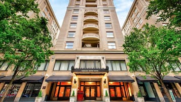 Un immeuble à plusieurs étages doté d’une entrée imposante, de grandes fenêtres et d’une enseigne indiquant qu’il s’agit de l’hôtel Embassy Suites.