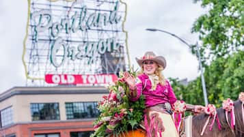 A person in traditional attire on a decorated horse, with a sign reading "Old Town" in the background.