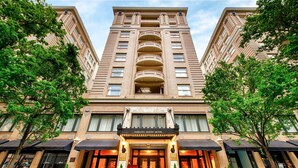 A multi-story building with a prominent entrance, large windows, and a sign indicating it is the Embassy Suites Hotel. - Embassy Suites by Hilton Portland Downtown (Portland)