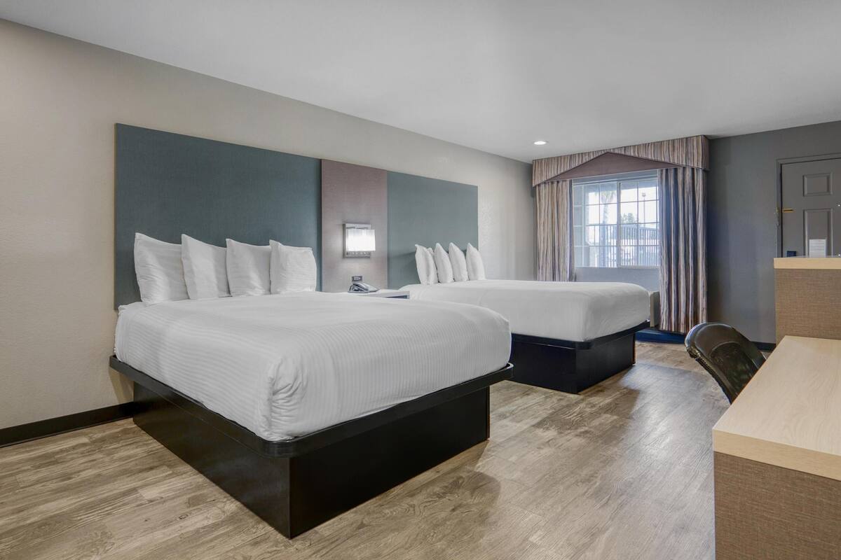 Standaard kamer, 2 queensize bedden, toegankelijk voor mindervaliden, roken | Een bureau, een laptopwerkplek, een strijkplank/strijkijzer