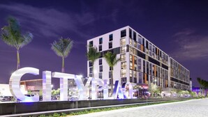 En moderne bygning med et tydeligt "CITYPLACE" skilt, der viser en flereetages konstruktion med store vinduer og et fladt tag.