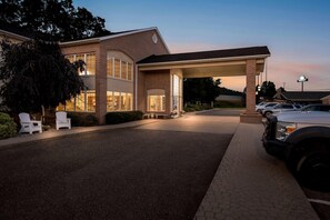 A hotel entrance with a covered driveway, a parking area, and a Days Inn sign. - Days Inn by Wyndham Lisbon (Lisbon)