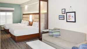 A hotel room with two beds, a sofa, a small table, and a wall with framed pictures. - Four Points by Sheraton Fayetteville Fort Bragg (Fayetteville)