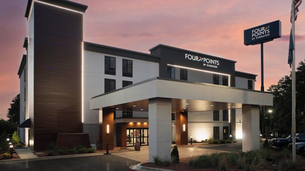 A modern hotel entrance with a sign reading "Four Points by Sheraton," featuring a two-story structure with a flat roof and a covered entrance area. - Four Points by Sheraton Fayetteville Fort Bragg (Fayetteville)