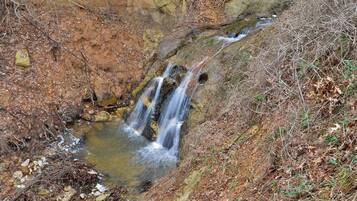 A natural water stream flowing over rocks in a wooded area.