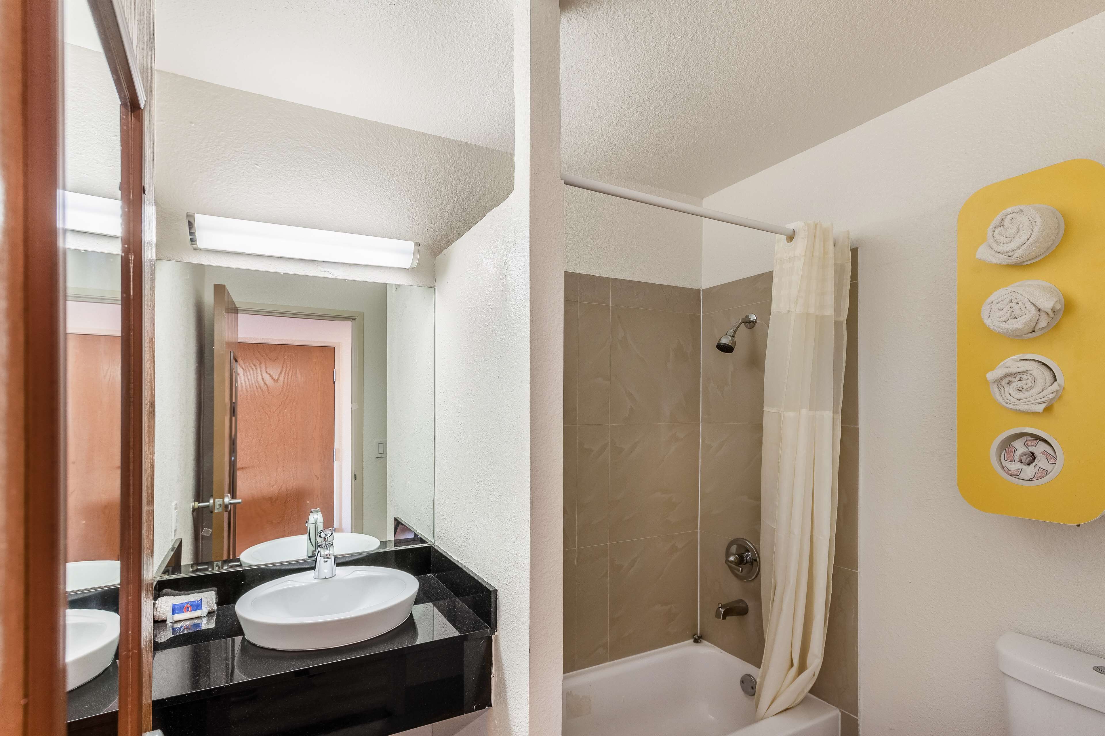 Une salle de bain avec un lavabo, un miroir et une douche.