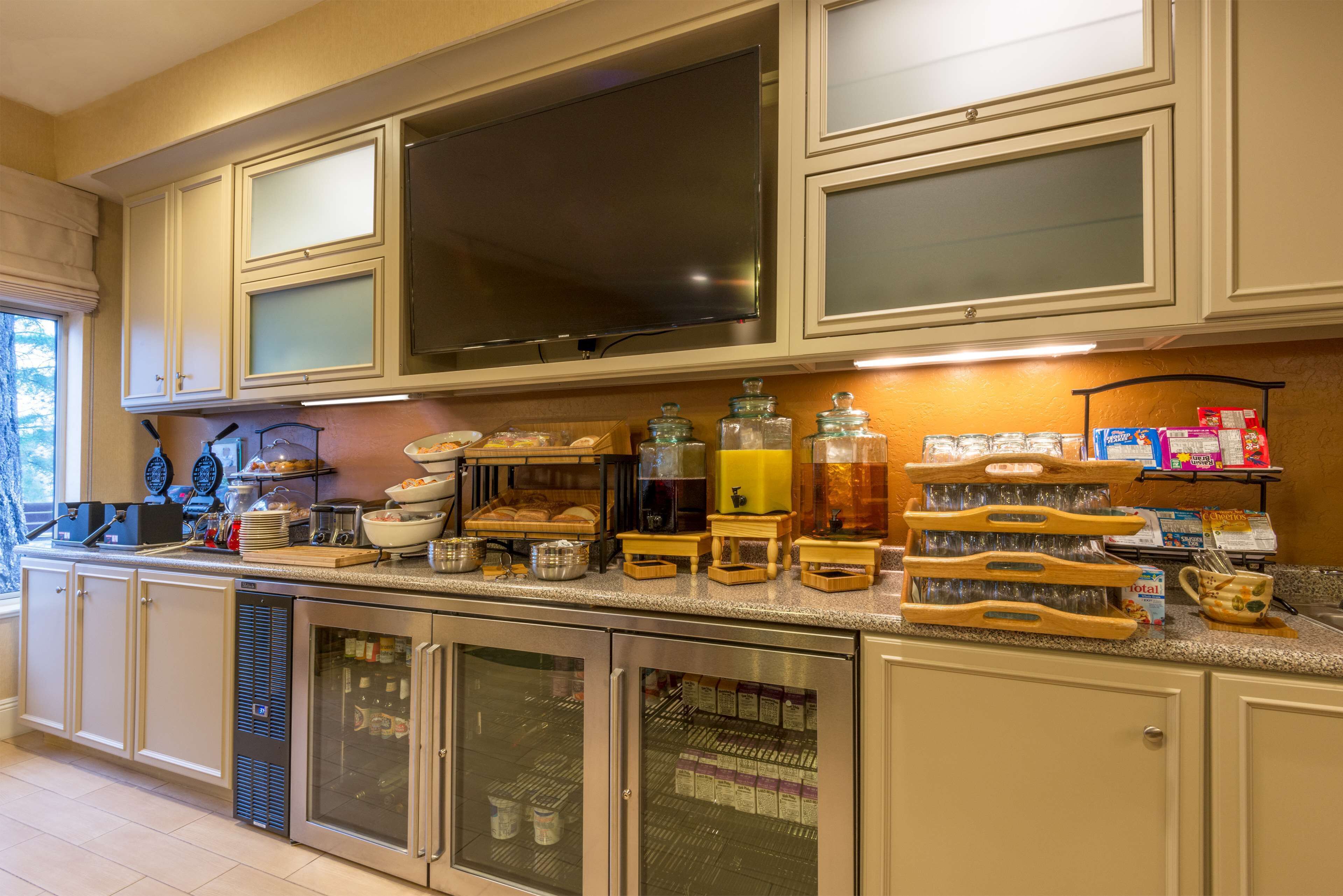Una cucina con un ampio televisore a schermo piatto, mobili a incasso e una varietà di elettrodomestici e utensili da cucina.