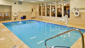 Relax by the clear pool, featuring a metal ladder and lifebuoy, amidst a clean and functional space.