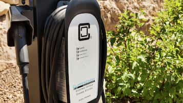 En laddstation för elfordon från ClipperCreek, med en kabel ansluten till den.