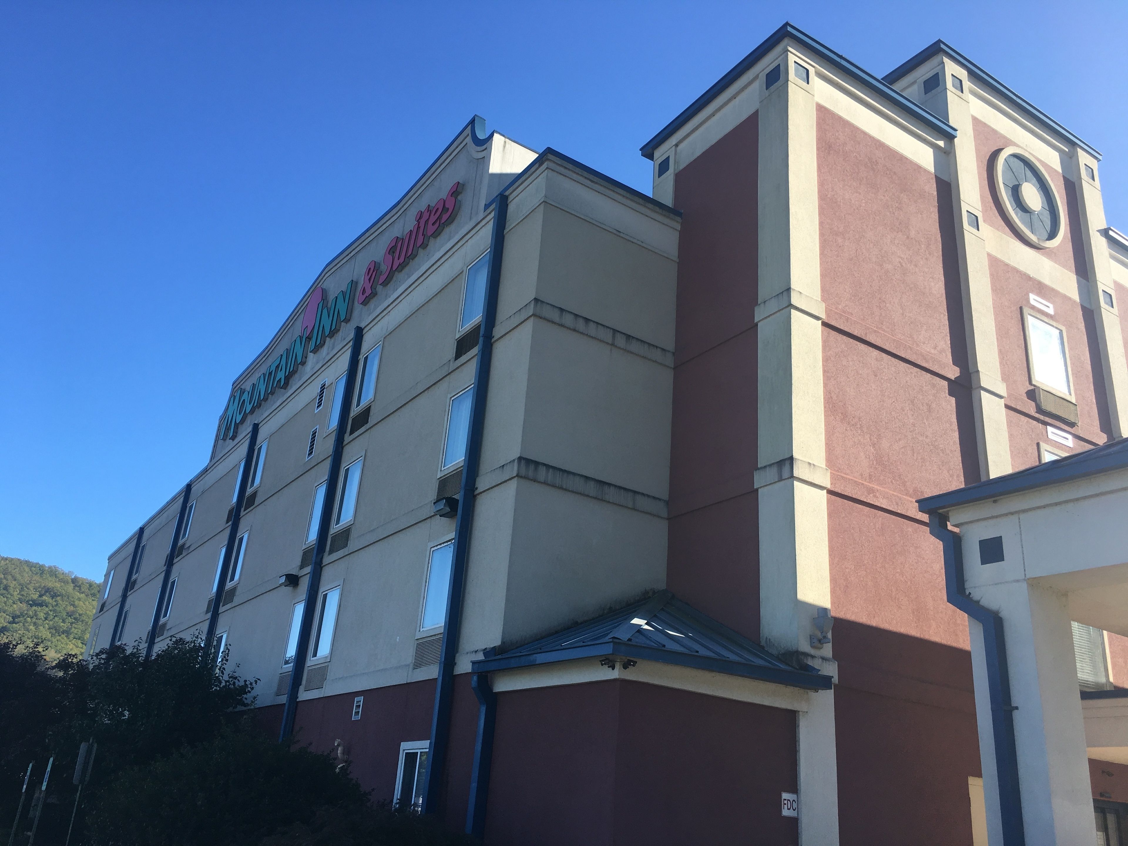 A hotel building with a sign reading "Mountain Inn Suites".