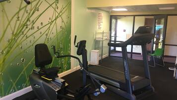 Una palestra con tapis roulant, ellittiche e attrezzature da parete.