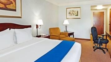 Een hotelkamer met een groot bed, een bureau, een stoel en twee lampen.