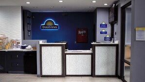 Un área de recepción con un letrero de Days Inn, un detector de incendios y un mostrador de check-in.
