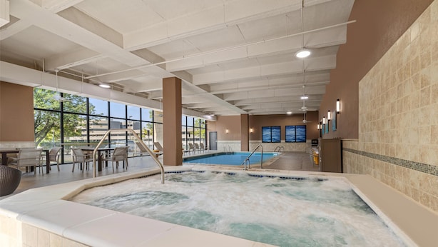 Eine Hotlobby mit Whirlpool, Pool und Sitzgelegenheiten im Freien.