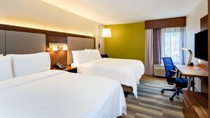 Une chambre d’hôtel avec deux lits, un bureau, une chaise, une télévision et une fenêtre avec des rideaux.