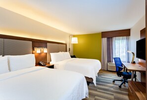 Habitación de hotel con dos camas, un escritorio, una silla, un televisor y una ventana con cortinas.
