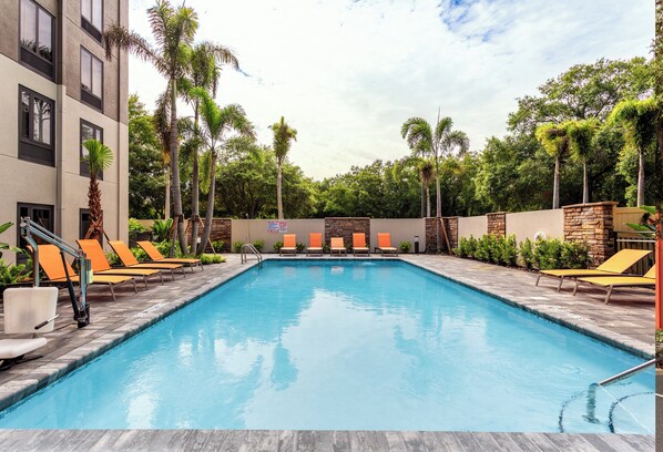 A swimming pool with lounge chairs and palm trees. - Holiday Inn Express Tampa-Brandon by IHG (Brandon)