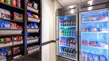 A vending machine stocked with snacks and beverages, including Pringles, Smartfood, and bottled water.
