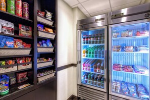 A vending machine stocked with snacks and beverages, including Pringles, Smartfood, and bottled water. - Holiday Inn Express Tampa-Brandon by IHG (Brandon)