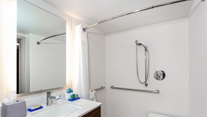 Une salle de bain moderne avec un lavabo blanc, un miroir et une douche.