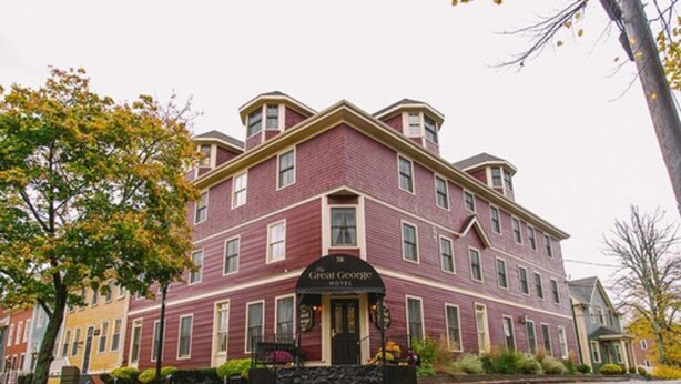 Un hotel histórico con una entrada imponente, varios pisos y un estilo arquitectónico clásico.