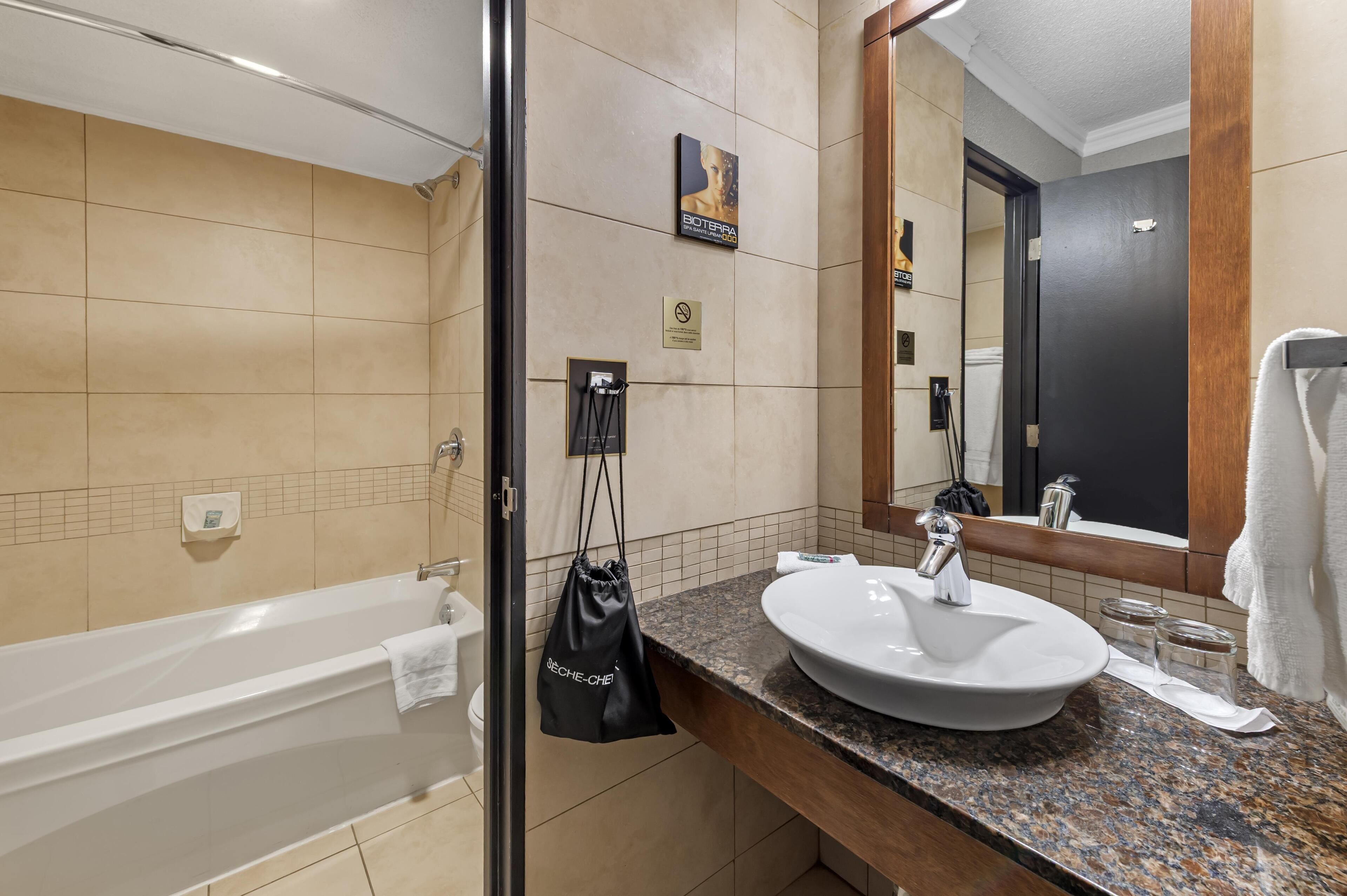Une salle de bain moderne avec une baignoire, un lavabo et un grand miroir.