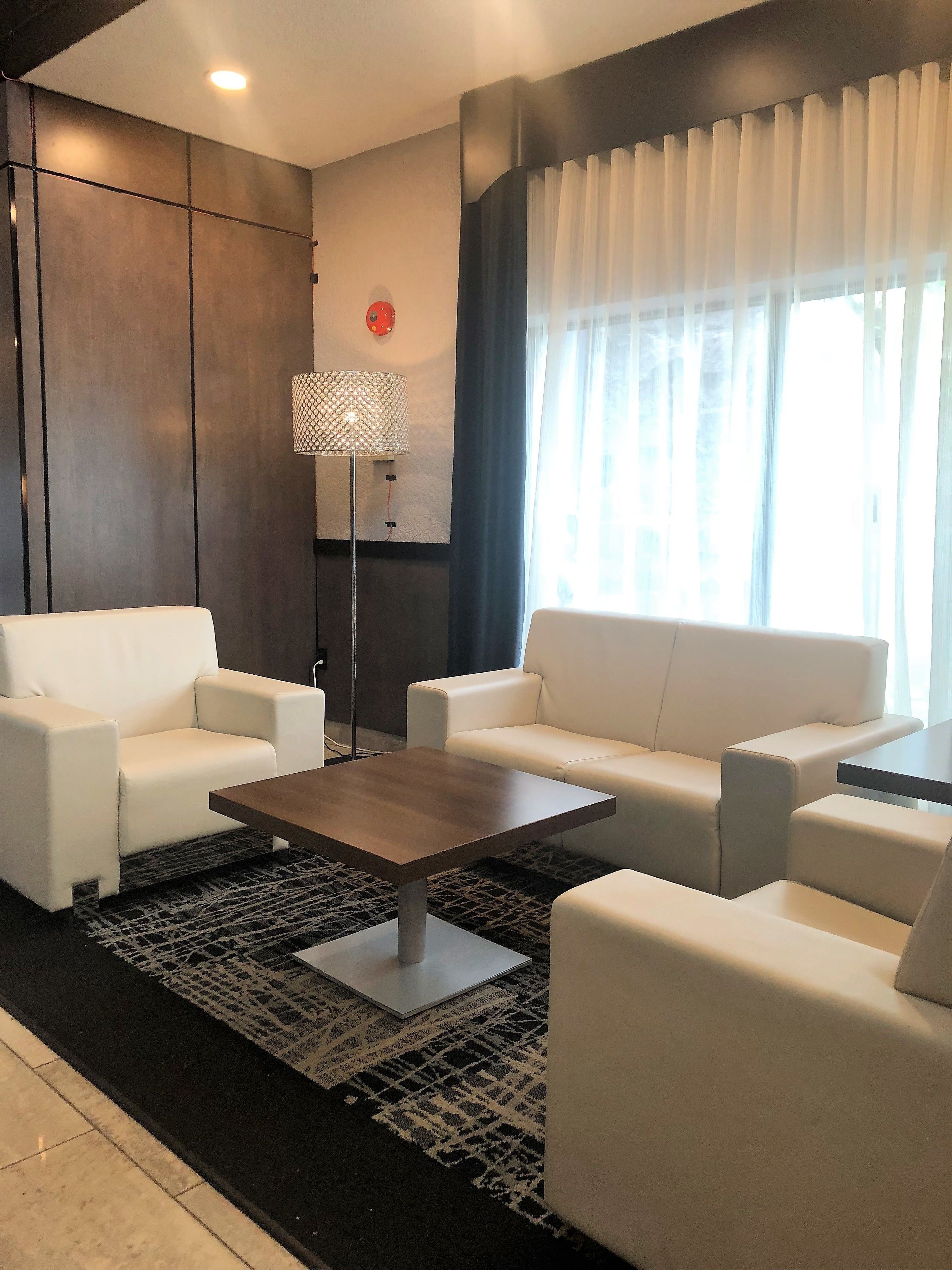 Una sala de estar moderna con un juego de sofá, una mesa de centro y una lámpara de pie.