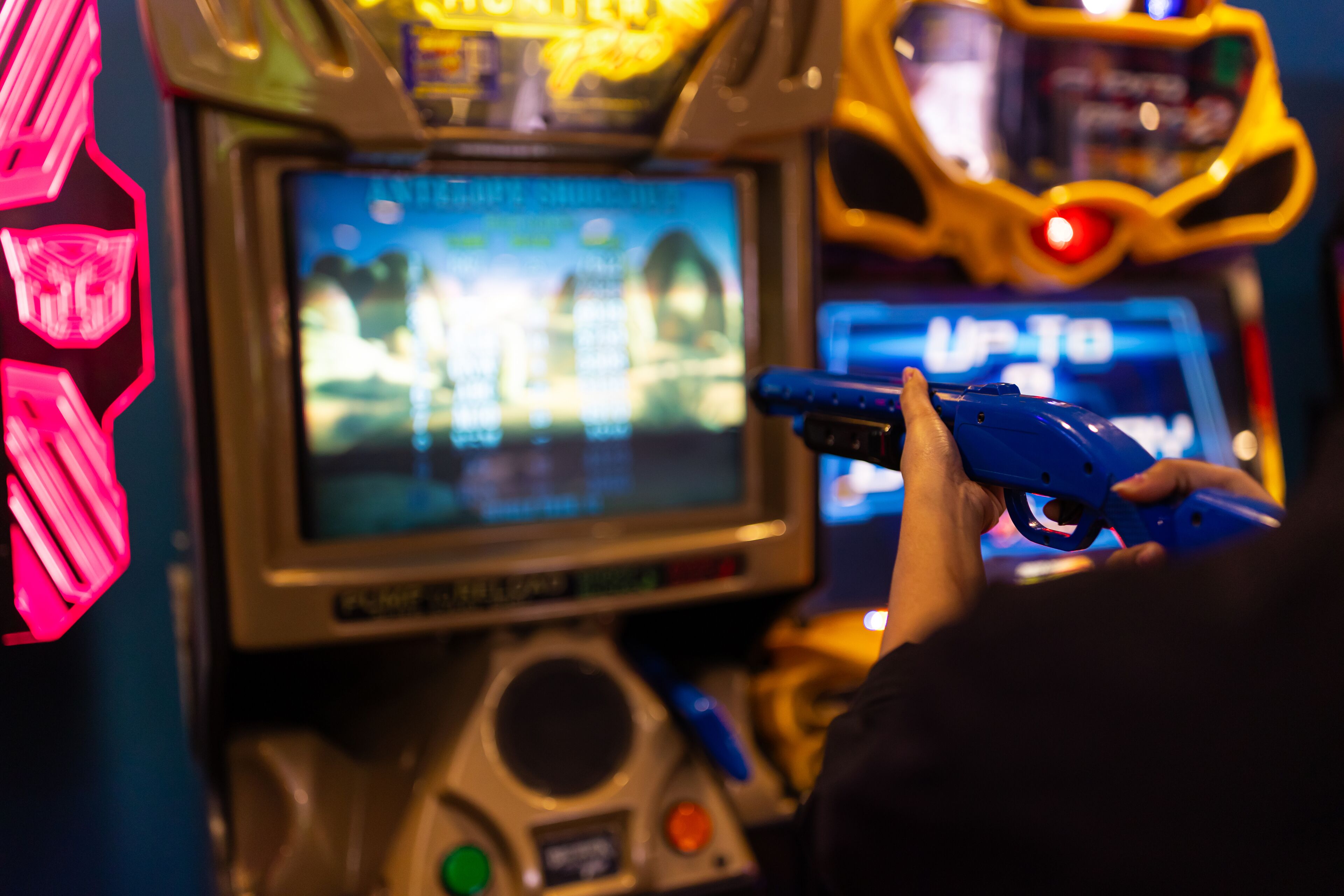 A person playing a video game on a gaming console with a screen displaying game graphics.